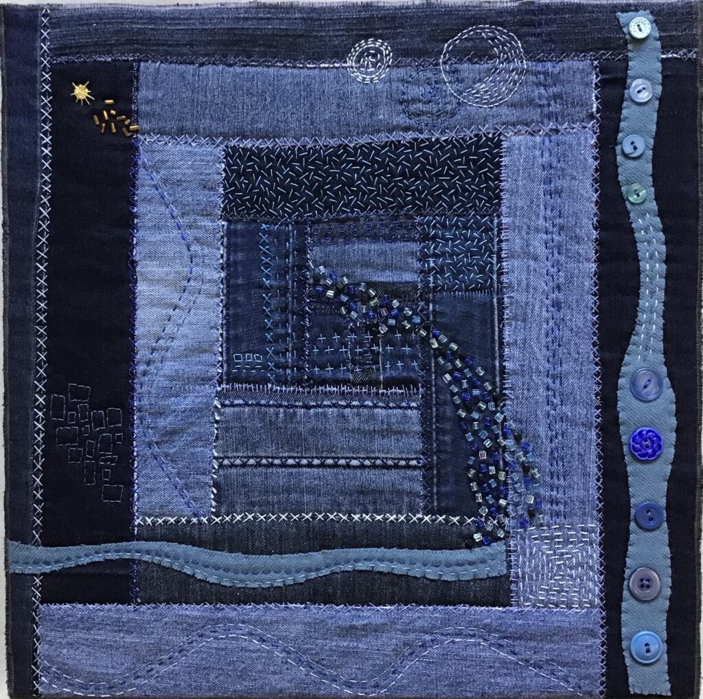 An abstract geometric patter of rectangles in blue with crisp patters overlaid with buttons, sequence, and white stitching.