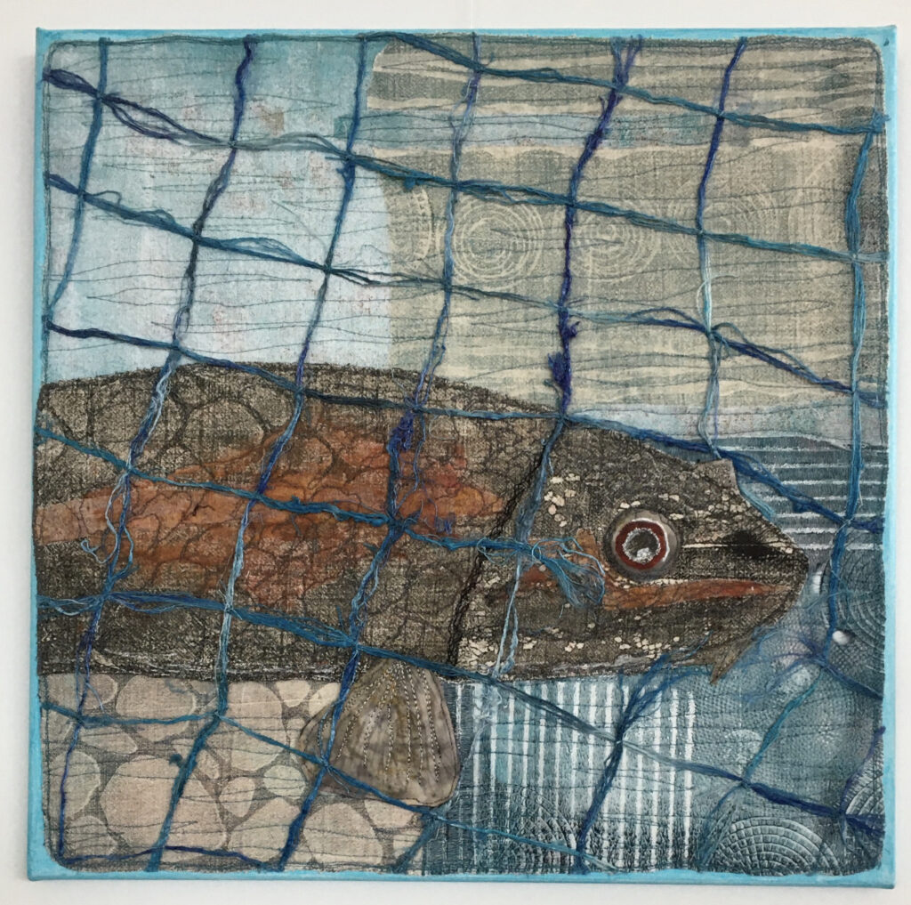 A green and orange fish pokes it's head through a break in blue netting.