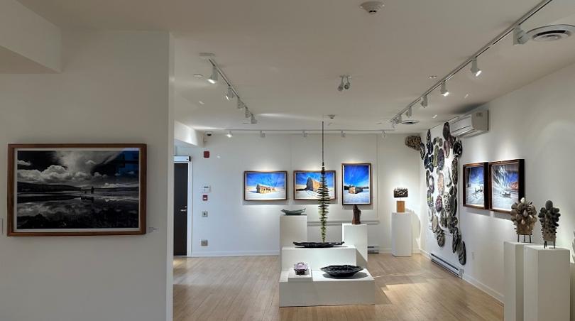 Interior of the Ferry Building Gallery, paintings and sculpture sit on white walls and white pedestals.