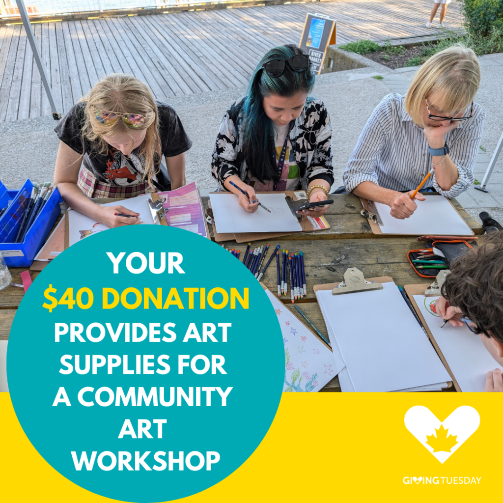 On a sunny summer boardwalk, participants sit at a wooden table with sketchbooks and pencils spread out around them.