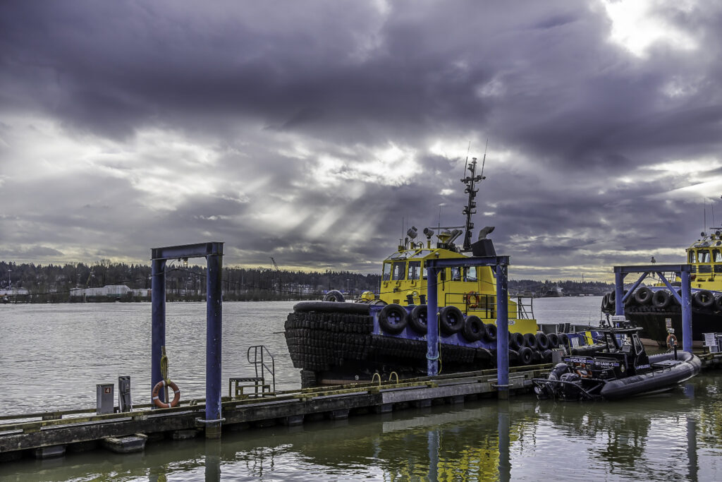 A yellow tug boat floats in the Fraser River at the New West Quay docks.