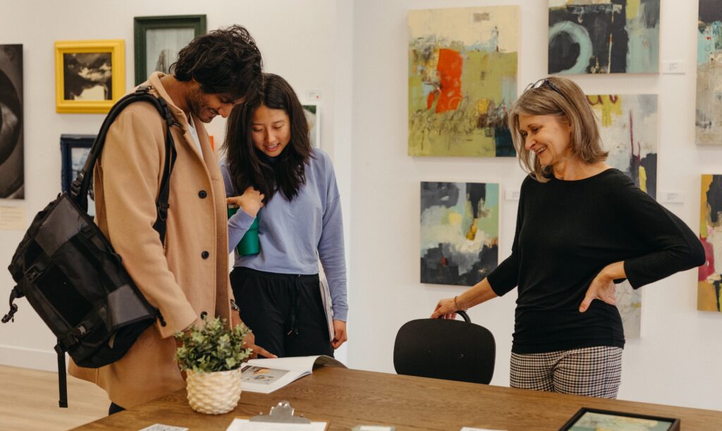 A couple looks through a brochure while an artist looks on