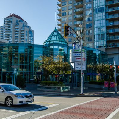 The green glass exterior of Royal City Centre facing the intersection of 6th and 6th.