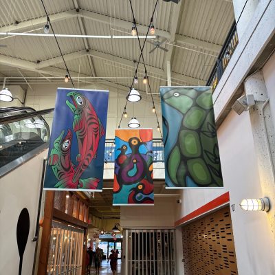 Three multicoloured banners in coast sailish and woodlands style hang from the rafters of River Market